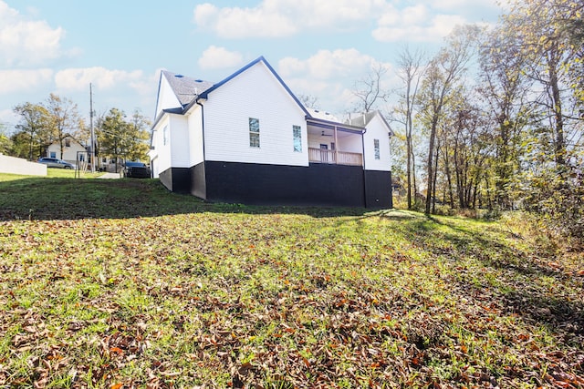 view of home's exterior with ceiling fan and a yard