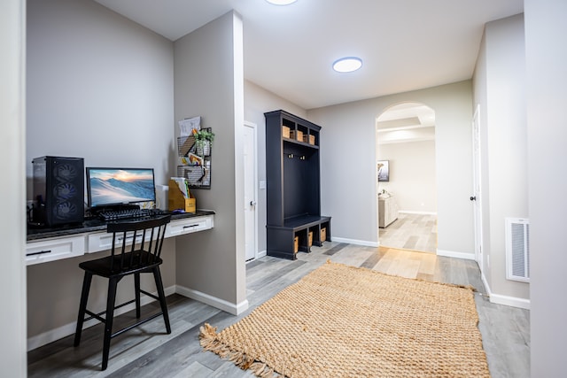 home office with hardwood / wood-style floors and built in desk