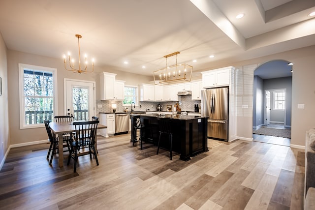 dining space featuring light hardwood / wood-style floors, sink, and a chandelier