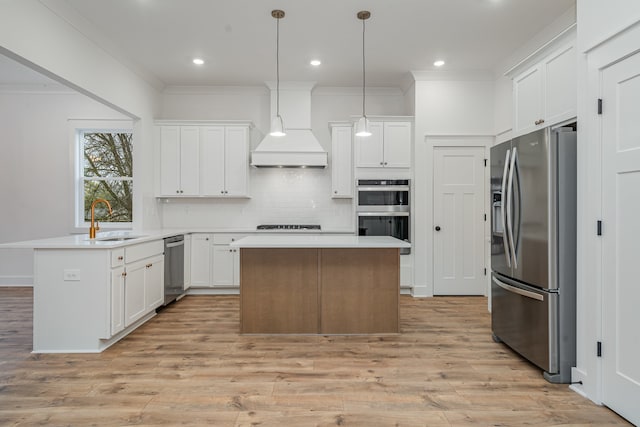 kitchen featuring a center island, appliances with stainless steel finishes, custom exhaust hood, and hanging light fixtures