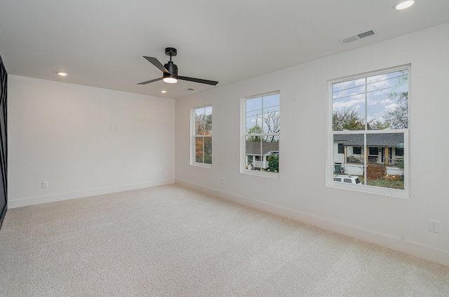 empty room with light colored carpet and a healthy amount of sunlight