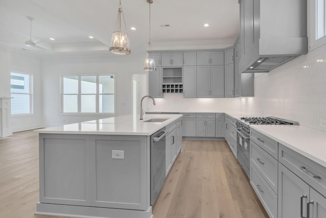 kitchen featuring gray cabinetry, appliances with stainless steel finishes, a sink, and custom range hood