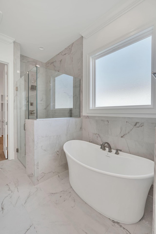 full bathroom featuring marble finish floor, a marble finish shower, ornamental molding, and a freestanding tub