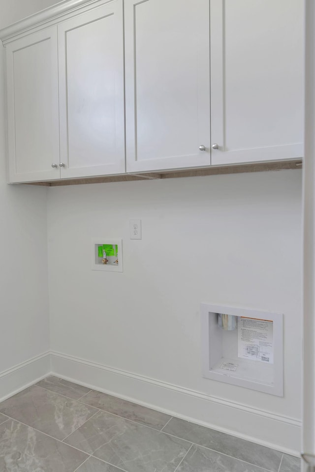 laundry room with cabinet space, baseboards, and washer hookup