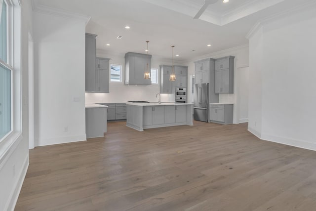 unfurnished living room with recessed lighting, a sink, baseboards, light wood-style floors, and ornamental molding