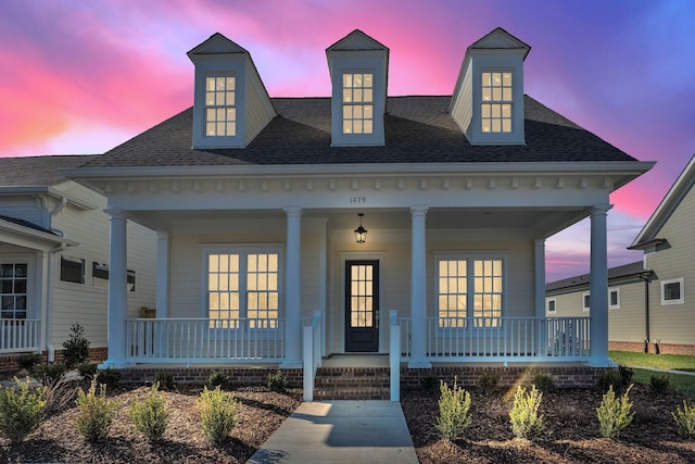 view of front of property with a porch and roof with shingles