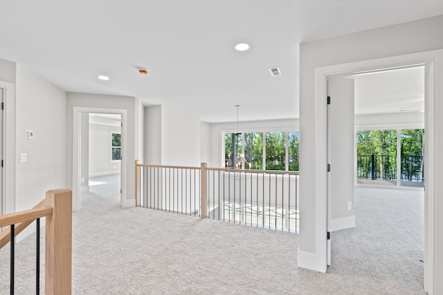 hall with light colored carpet