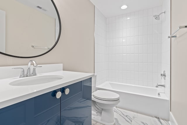 full bathroom with vanity, tiled shower / bath combo, and toilet