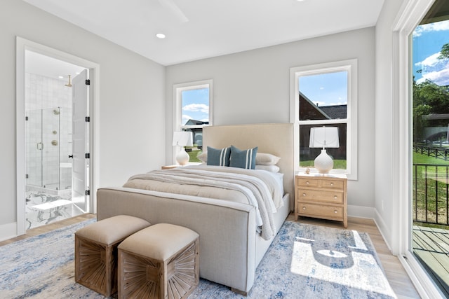 bedroom with access to exterior, connected bathroom, and light hardwood / wood-style flooring