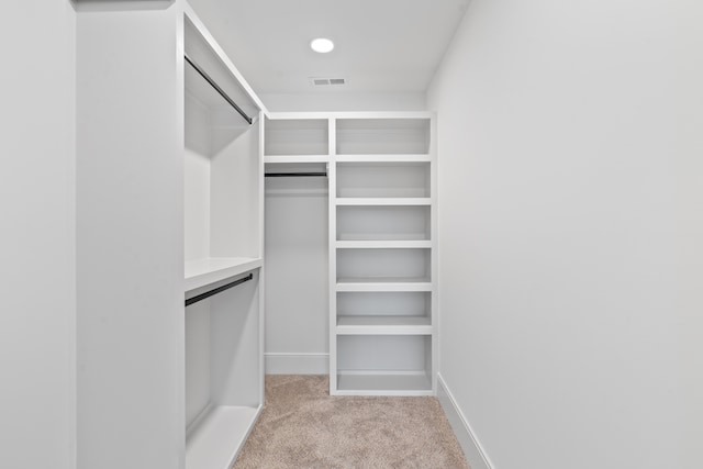 walk in closet featuring light colored carpet