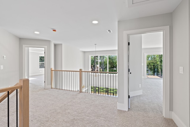 hall with light colored carpet