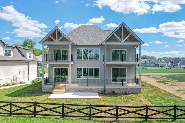 back of property with covered porch, a balcony, and ceiling fan