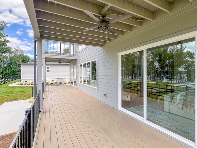 deck featuring ceiling fan and a lawn