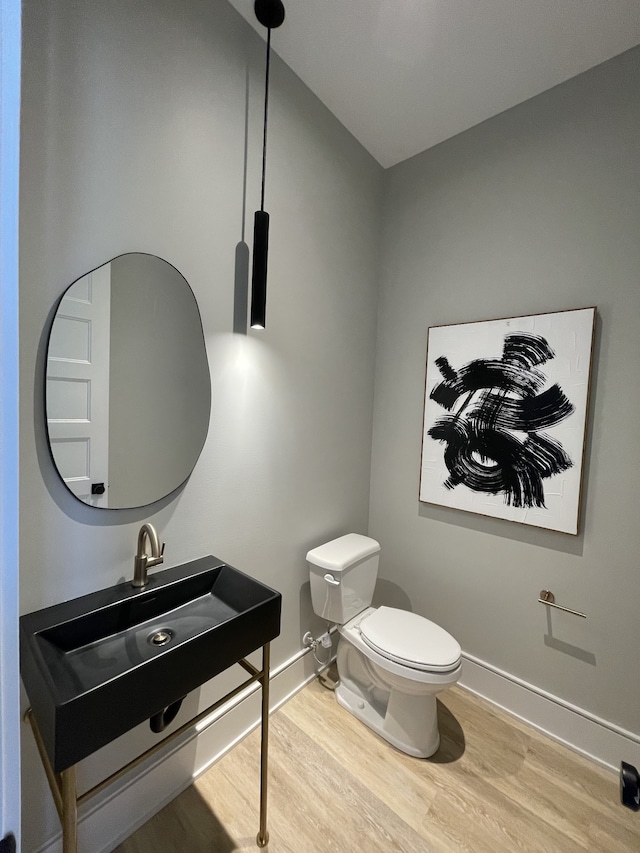 bathroom featuring sink, wood-type flooring, and toilet