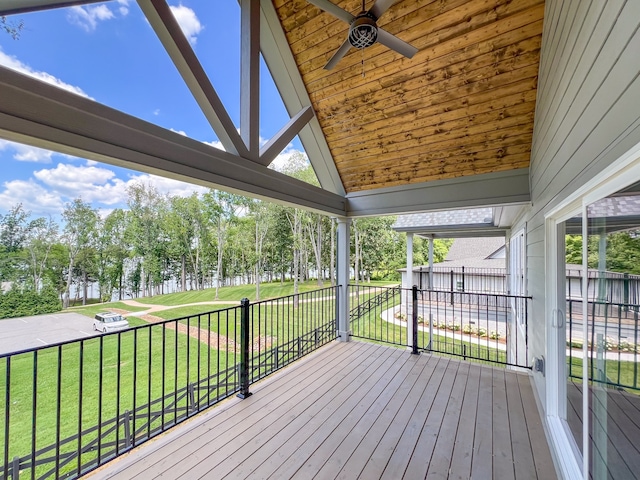 wooden terrace featuring a lawn and ceiling fan