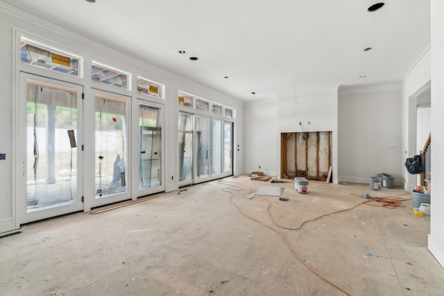 unfurnished living room with ornamental molding and a wealth of natural light