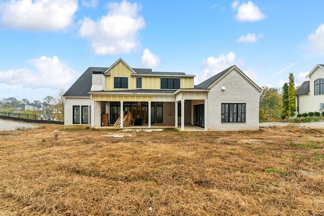 rear view of property featuring board and batten siding and a patio area