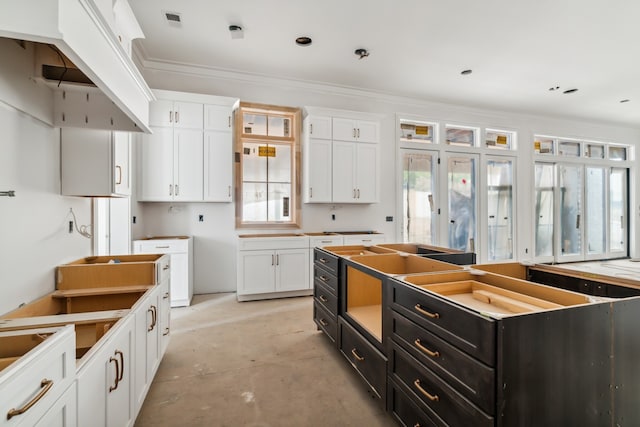 kitchen featuring a center island, white cabinetry, and crown molding