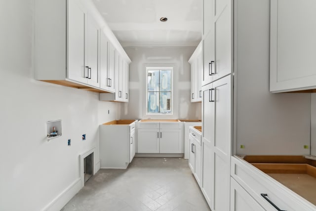 clothes washing area with cabinets and hookup for a washing machine