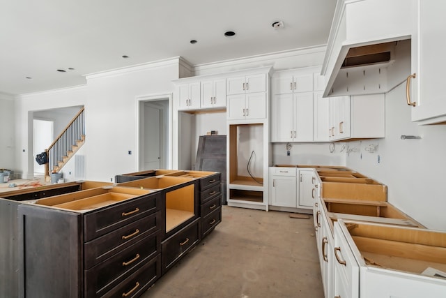 kitchen with a center island, white cabinetry, and ornamental molding