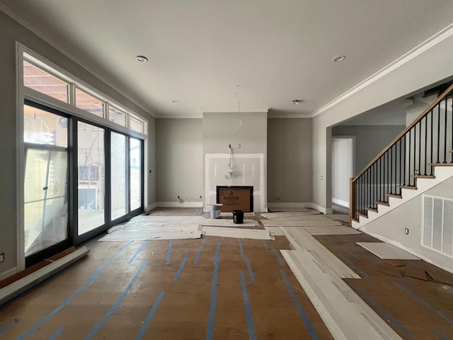 unfurnished living room featuring recessed lighting, visible vents, baseboards, ornamental molding, and stairway