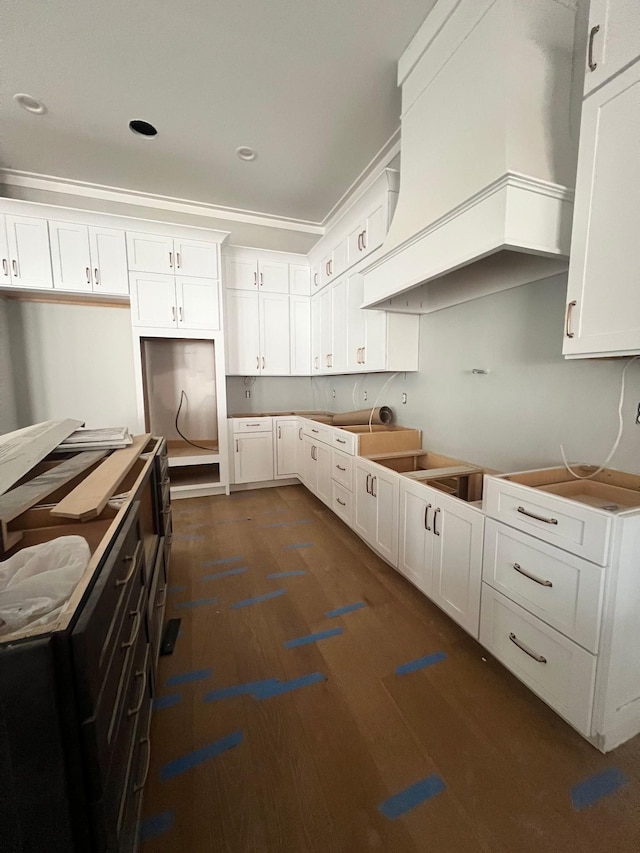 kitchen featuring dark wood-style flooring, premium range hood, and white cabinetry