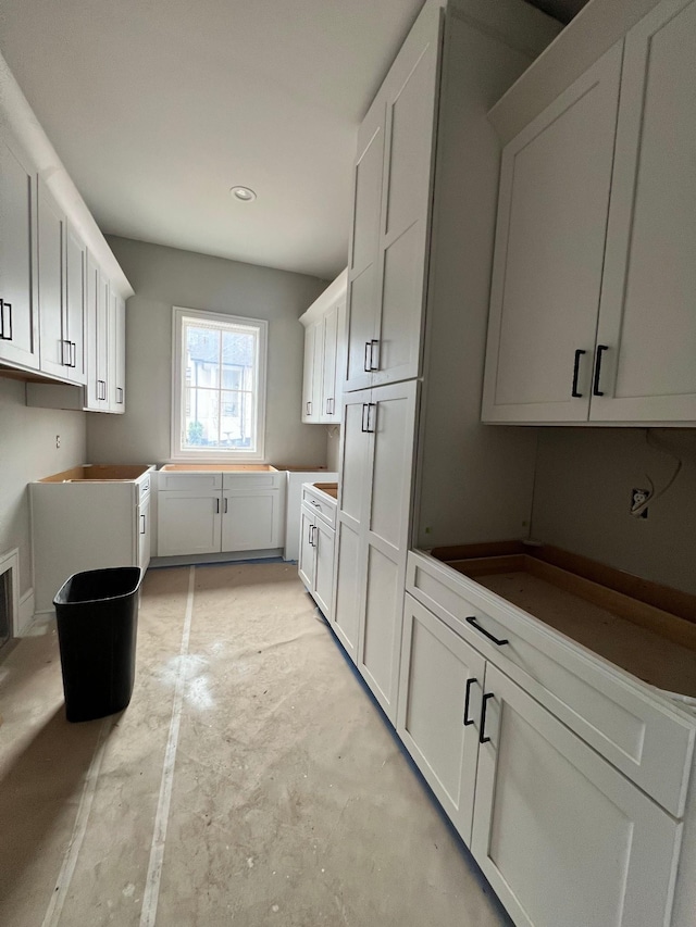 kitchen with concrete floors and white cabinets