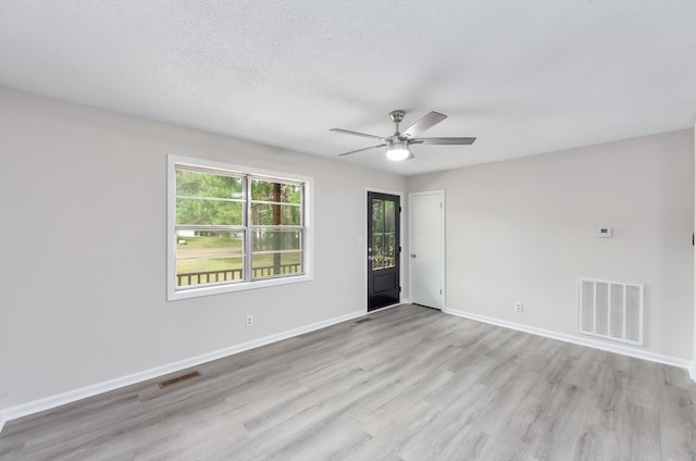 unfurnished room with a textured ceiling, light hardwood / wood-style flooring, and ceiling fan