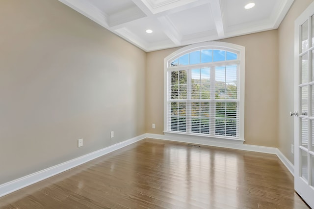 spare room with coffered ceiling, hardwood / wood-style floors, and beam ceiling