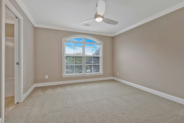 spare room featuring ornamental molding, light colored carpet, and ceiling fan