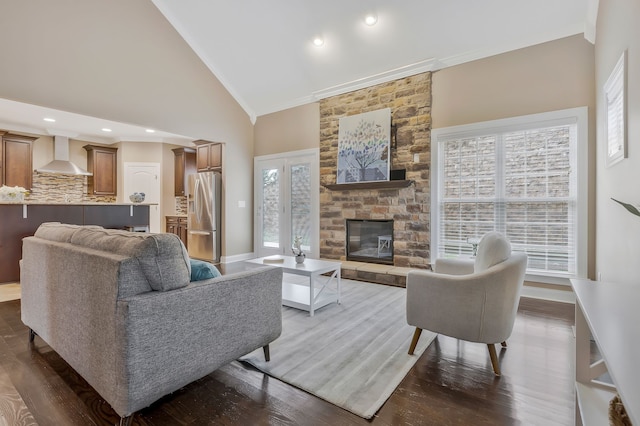 living room featuring high vaulted ceiling, dark hardwood / wood-style flooring, crown molding, and a fireplace