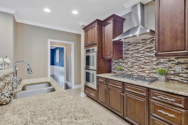 kitchen with stainless steel appliances, wall chimney exhaust hood, sink, and ornamental molding