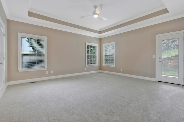 carpeted spare room featuring ceiling fan, a raised ceiling, and crown molding