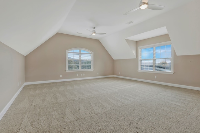 additional living space with vaulted ceiling, light colored carpet, and ceiling fan