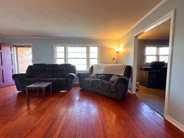 living room featuring dark hardwood / wood-style floors, crown molding, a textured ceiling, and a wealth of natural light