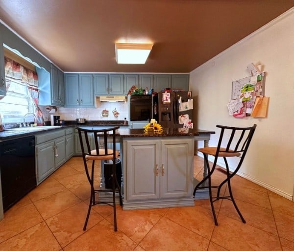 kitchen featuring decorative backsplash, gray cabinetry, sink, black appliances, and light tile patterned flooring