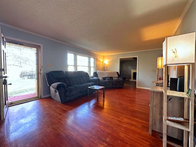 living room with a fireplace, a textured ceiling, dark hardwood / wood-style floors, and crown molding