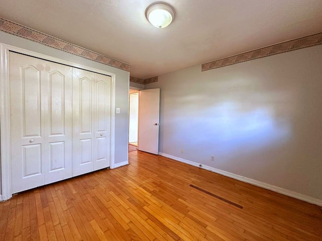 unfurnished bedroom featuring a closet and light hardwood / wood-style flooring