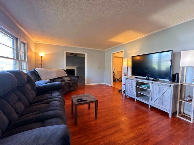 living room featuring hardwood / wood-style floors, a textured ceiling, ceiling fan, and crown molding