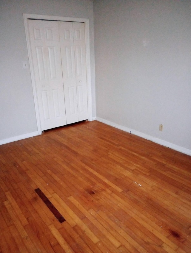 unfurnished bedroom with wood-type flooring and a closet