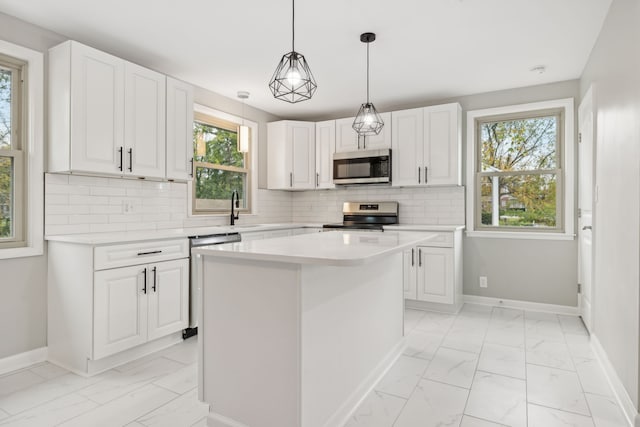 kitchen featuring a kitchen island, white cabinetry, backsplash, and stainless steel appliances