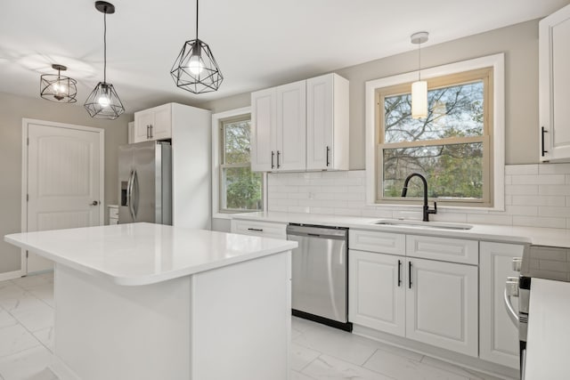 kitchen with a kitchen island, white cabinets, decorative backsplash, and stainless steel appliances