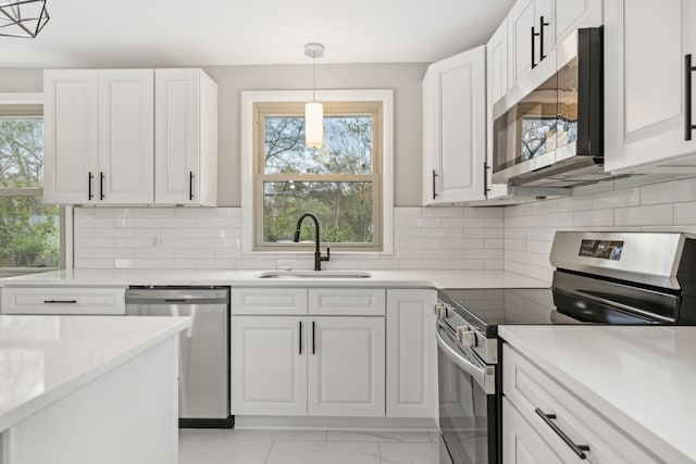 kitchen with appliances with stainless steel finishes, sink, and white cabinets