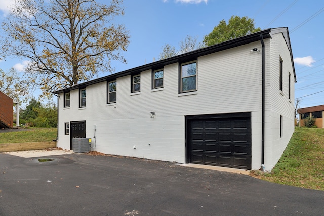 view of side of property with central AC unit and a garage