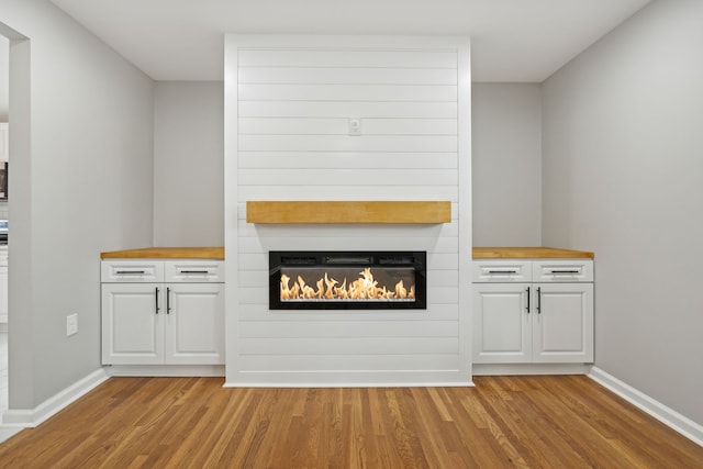 unfurnished living room with light wood-type flooring and a large fireplace