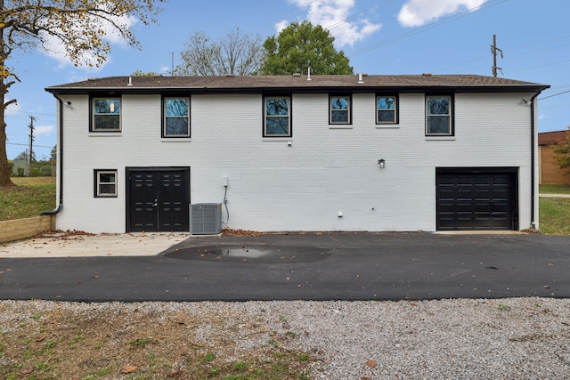 exterior space with a garage and central AC