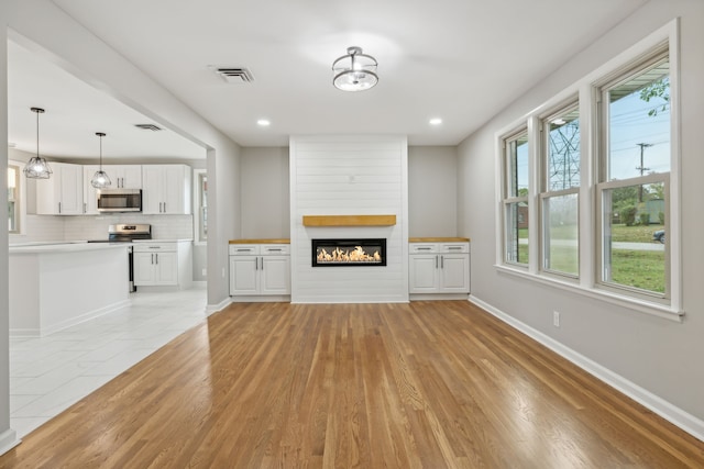 unfurnished living room featuring a fireplace and light hardwood / wood-style flooring