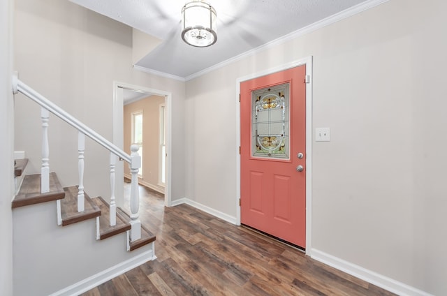 foyer entrance with dark wood-type flooring, a textured ceiling, and ornamental molding