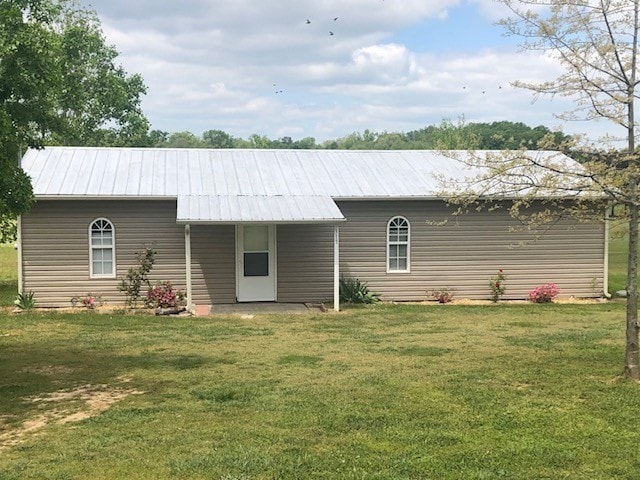 rear view of property with a yard