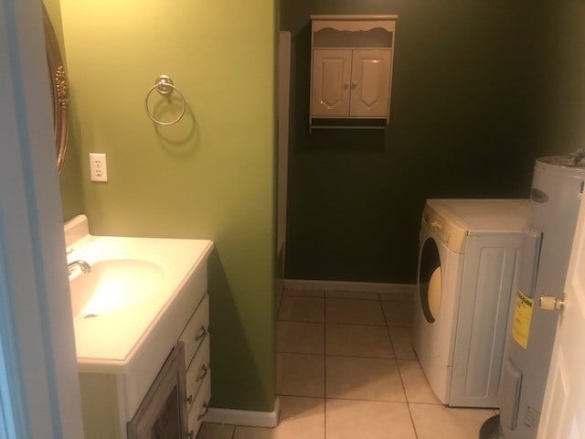 bathroom featuring vanity, washer / dryer, water heater, and tile patterned floors